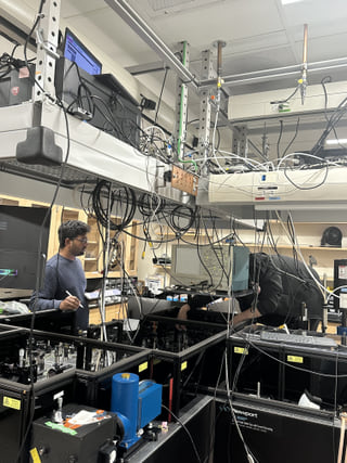 Saptarsi Mondal adjusting optics on the ultrafast spectroscopy table in the Baiz lab at UT Austin.